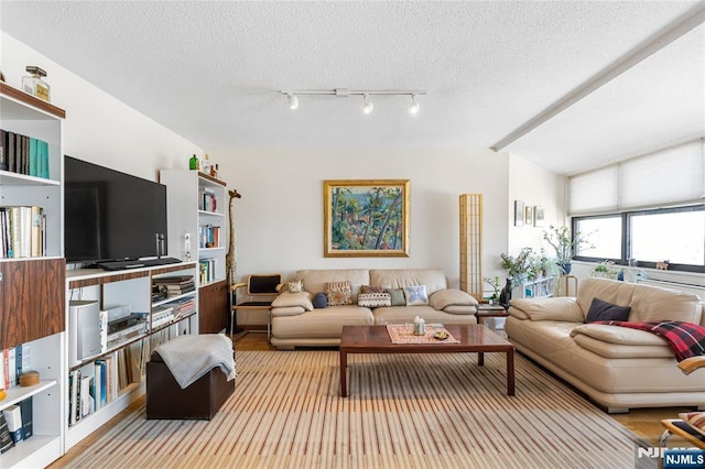 living room with lofted ceiling with beams and a textured ceiling