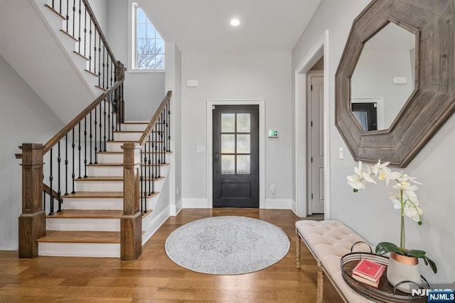 entrance foyer with baseboards, stairway, wood finished floors, and recessed lighting