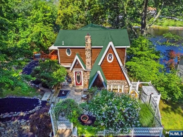 view of front of property with stone siding and a chimney