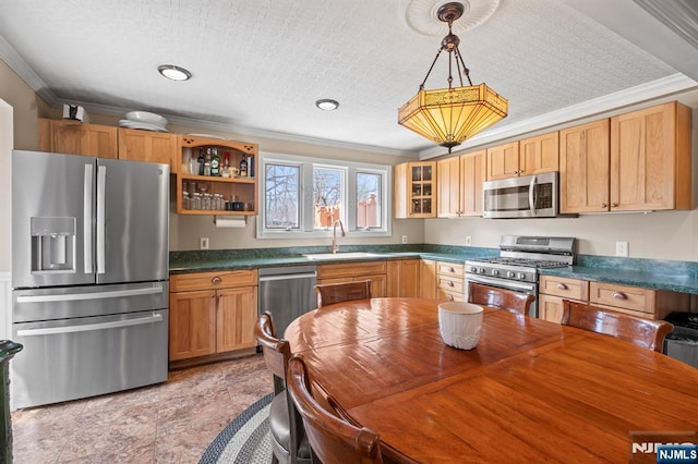 kitchen featuring stainless steel appliances, a sink, ornamental molding, dark countertops, and glass insert cabinets