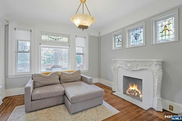 sitting room featuring wood finished floors, a high end fireplace, and baseboards