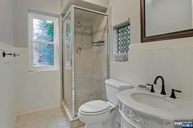 full bath with a stall shower, a wainscoted wall, vanity, and toilet