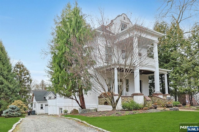 view of front of house with covered porch and a front lawn