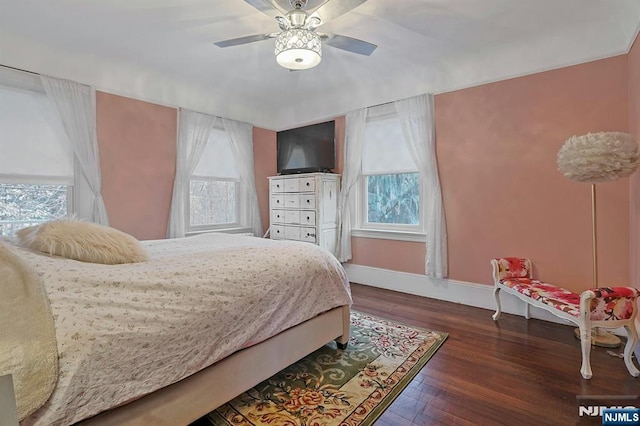 bedroom featuring ceiling fan, baseboards, and wood finished floors