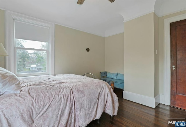 bedroom featuring dark wood-type flooring, crown molding, baseboards, and ceiling fan