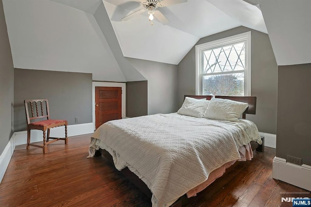 bedroom with dark wood-style floors, baseboards, vaulted ceiling, and a ceiling fan