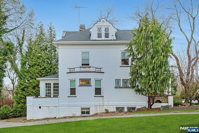 view of home's exterior featuring a shingled roof, a lawn, and a chimney