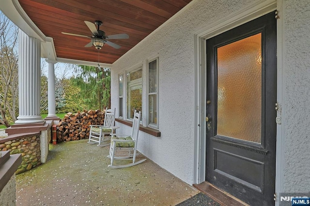 doorway to property with ceiling fan, a porch, and stucco siding