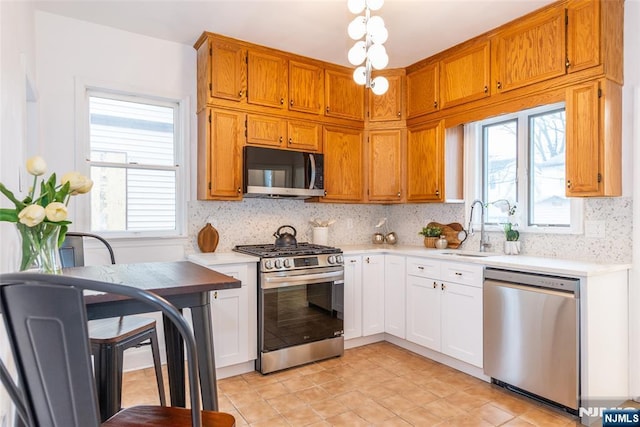 kitchen with light countertops, appliances with stainless steel finishes, and tasteful backsplash