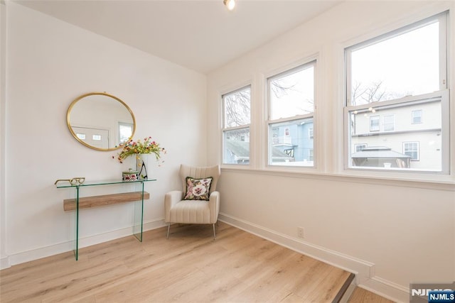 living area featuring baseboards and wood finished floors