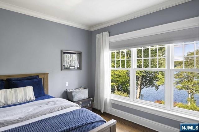 bedroom with crown molding, baseboards, and wood finished floors