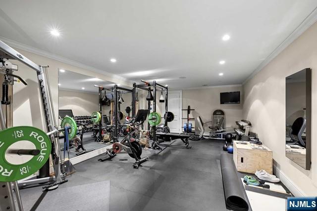 exercise area featuring baseboards, crown molding, and recessed lighting