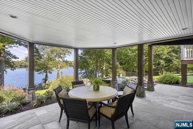 view of patio featuring a water view and outdoor dining space