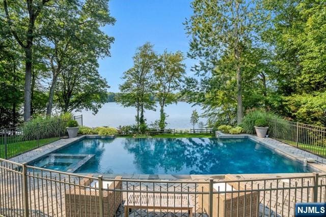 view of swimming pool featuring a pool with connected hot tub and fence