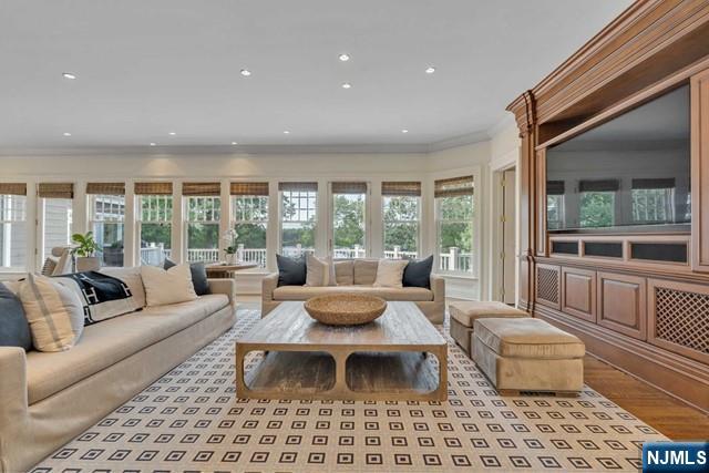 living room featuring ornamental molding, recessed lighting, and wood finished floors