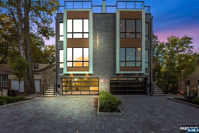 view of front facade featuring an attached garage, driveway, and brick siding