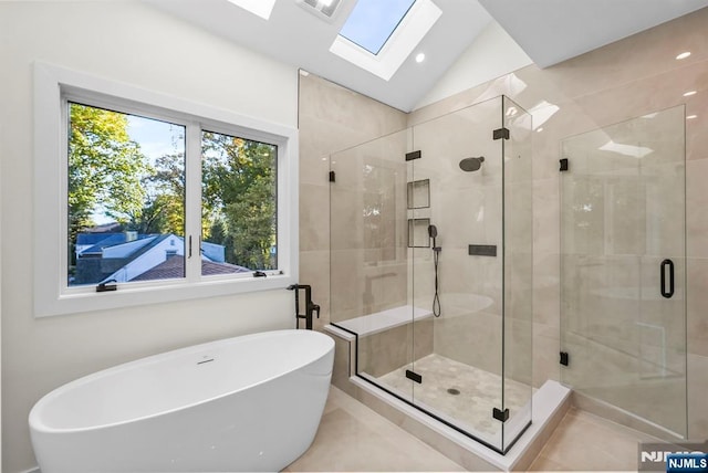 bathroom featuring vaulted ceiling with skylight, recessed lighting, a freestanding tub, and a shower stall