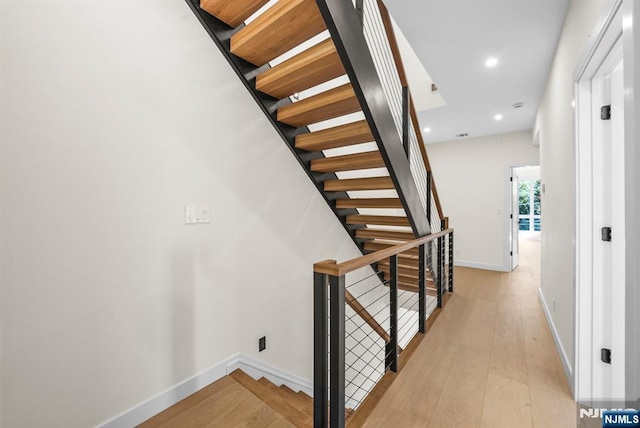 stairway with hardwood / wood-style flooring, baseboards, and recessed lighting