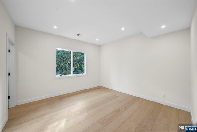 spare room featuring light wood-style floors, recessed lighting, visible vents, and baseboards