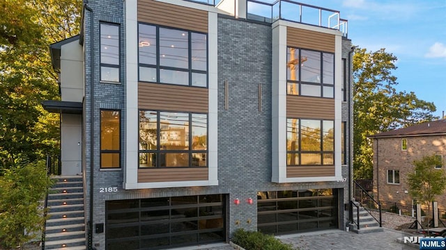 view of front of home featuring stairway and brick siding