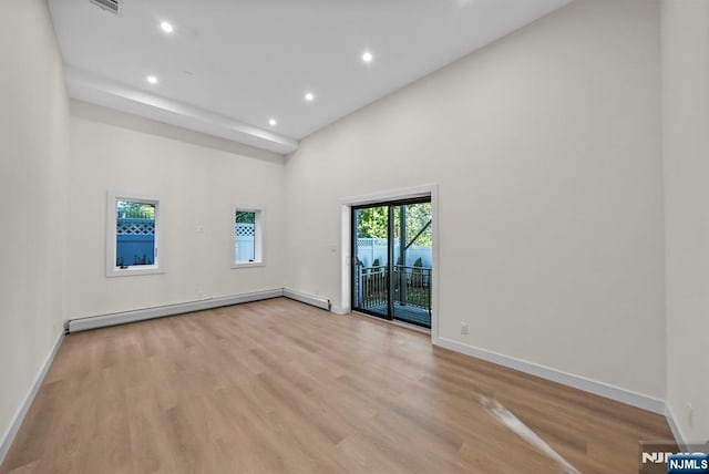 spare room with a baseboard heating unit, recessed lighting, light wood-style flooring, and baseboards