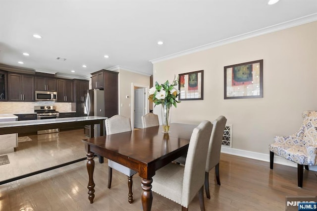 dining room featuring crown molding, recessed lighting, visible vents, wood finished floors, and baseboards