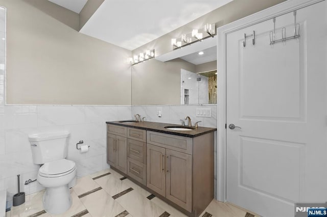 bathroom with a sink, toilet, and double vanity