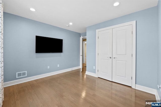 unfurnished bedroom with baseboards, visible vents, wood finished floors, and recessed lighting