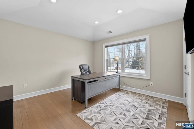 office space featuring recessed lighting, visible vents, vaulted ceiling, wood finished floors, and baseboards