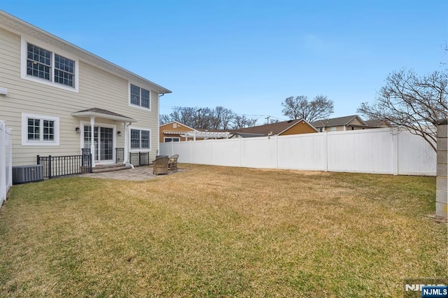 view of yard featuring a patio area, fence, and central AC unit