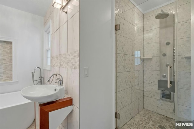 bathroom featuring ornamental molding, a stall shower, a soaking tub, and vanity