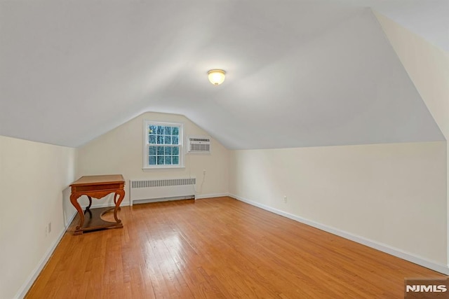 bonus room with radiator, baseboards, vaulted ceiling, and hardwood / wood-style floors