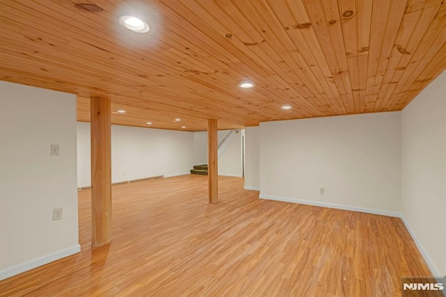 finished below grade area featuring recessed lighting, stairway, light wood-type flooring, wooden ceiling, and baseboards