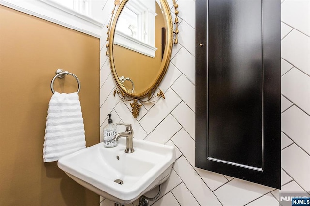 bathroom with tile walls and a sink