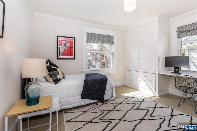 bedroom with a closet, light carpet, crown molding, and baseboards