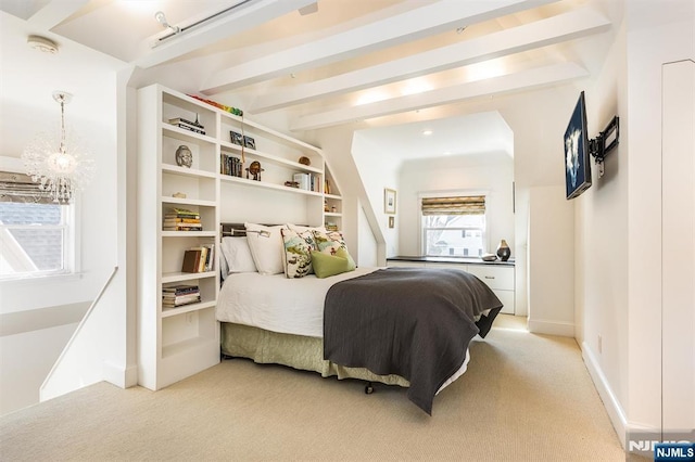 bedroom with beam ceiling, light carpet, and baseboards