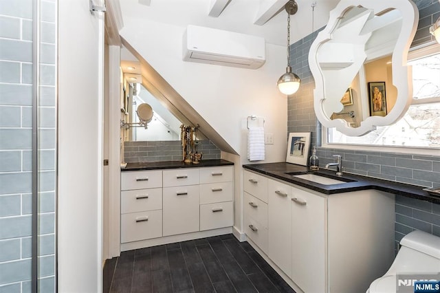 kitchen with dark countertops, decorative backsplash, and a wall mounted air conditioner