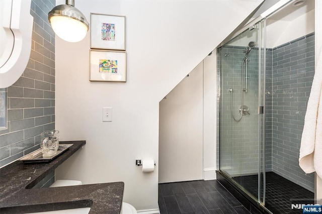 bathroom with a stall shower, wood finish floors, and toilet