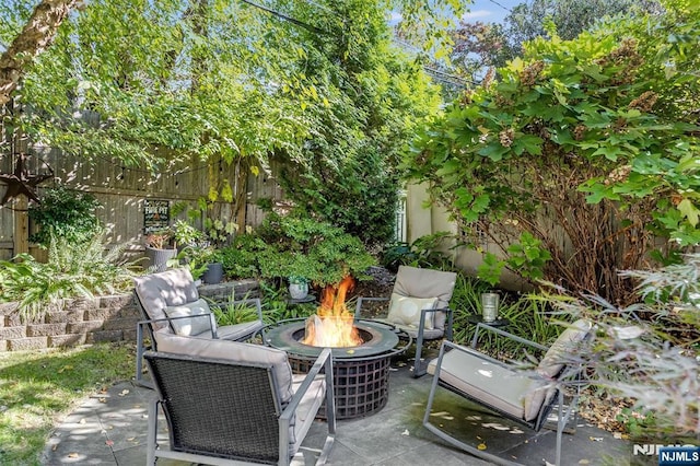 view of patio featuring an outdoor fire pit and fence