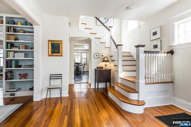 stairs with visible vents, hardwood / wood-style floors, a wealth of natural light, and baseboards