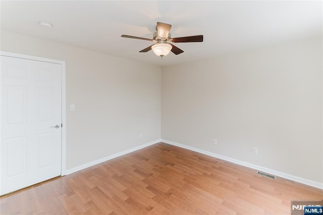 empty room with ceiling fan, light wood-type flooring, visible vents, and baseboards