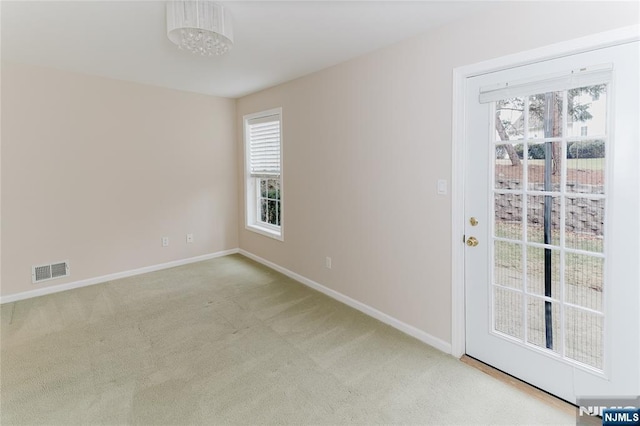 carpeted empty room with visible vents and baseboards