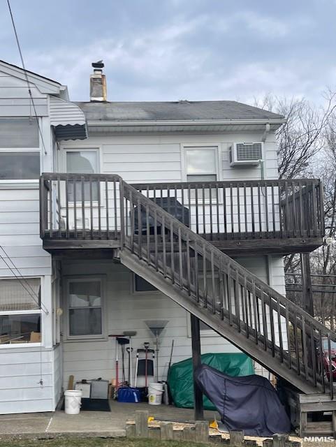 77 Shepherds Ln, Totowa, NJ 07512 - back of property featuring a chimney, a wall mounted air conditioner, and stairway