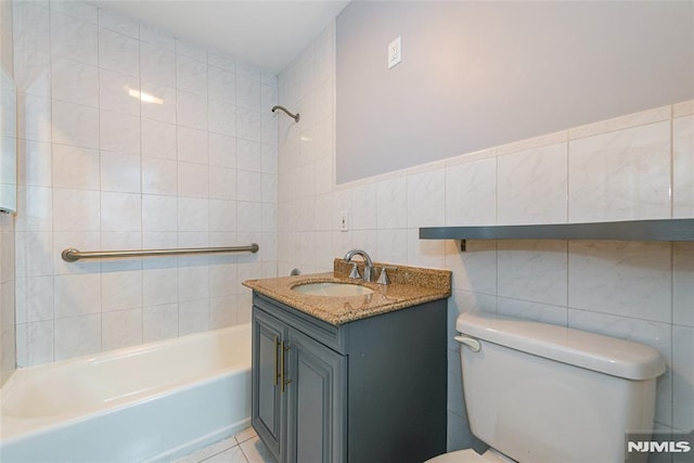 full bath featuring washtub / shower combination, tile walls, toilet, and vanity