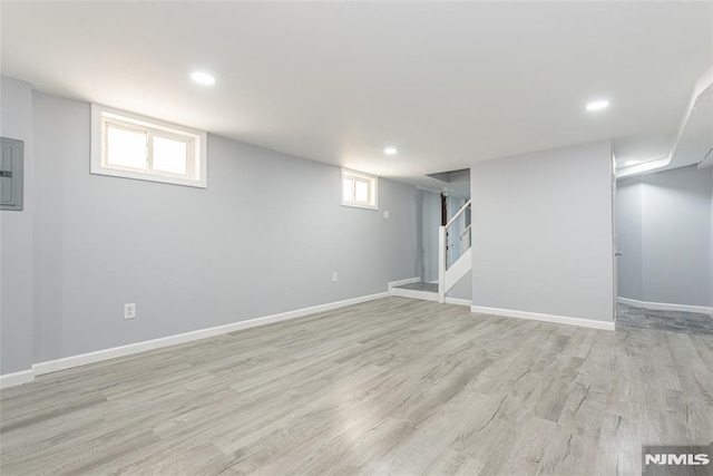 basement with stairs, recessed lighting, light wood-type flooring, and baseboards