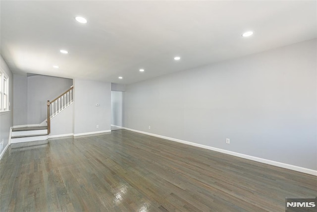 unfurnished living room with stairs, baseboards, wood finished floors, and recessed lighting