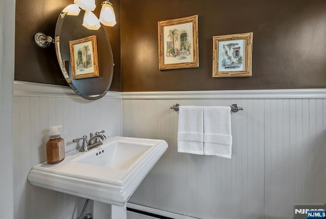 bathroom with a wainscoted wall and a sink