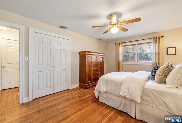 bedroom featuring visible vents, ceiling fan, baseboards, light wood-type flooring, and a closet