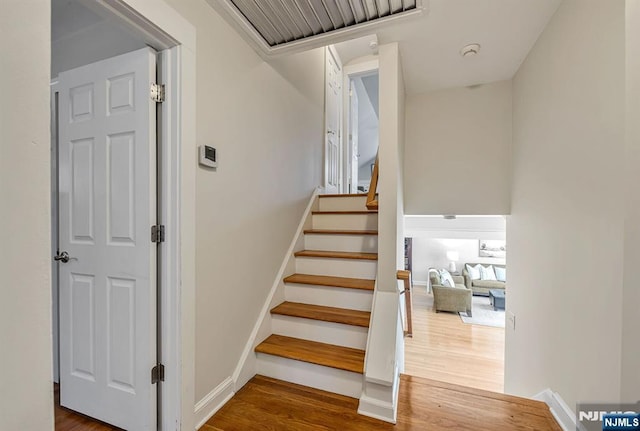 staircase with wood finished floors and baseboards