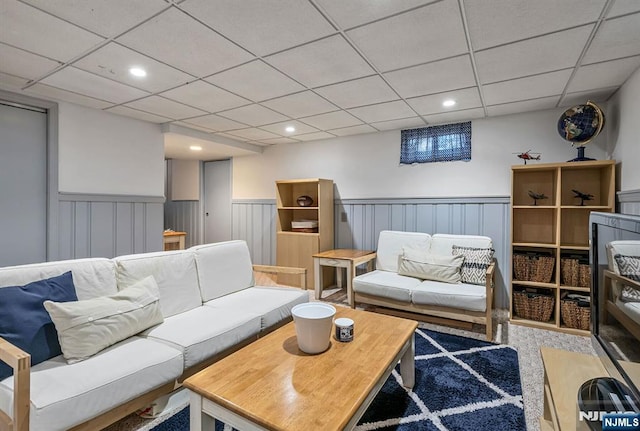 living area featuring recessed lighting, a wainscoted wall, and a drop ceiling